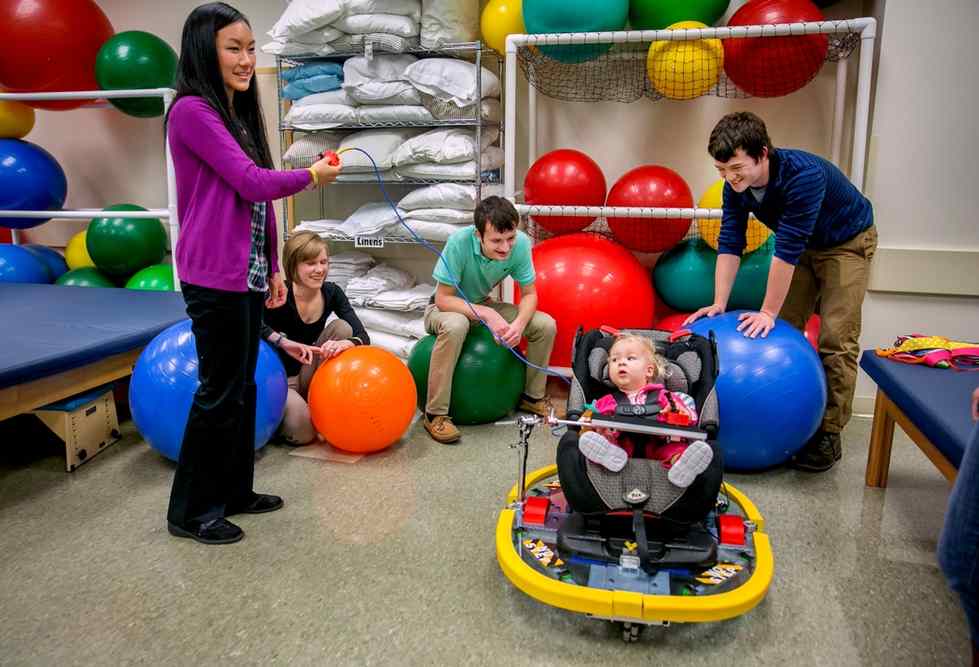 Students watch Lylah Gritter in the Play and Mobility Device